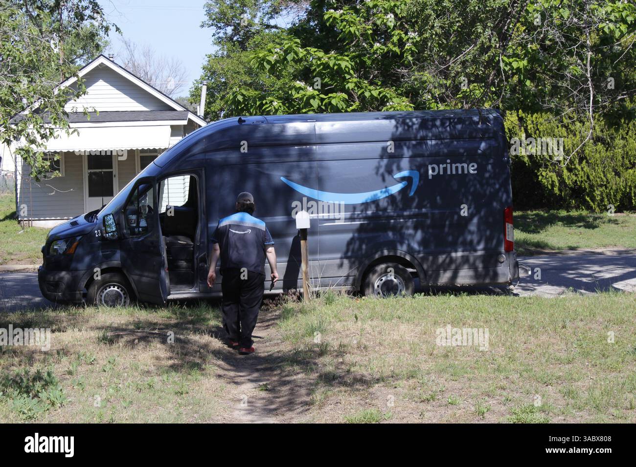 AMAZON Prime-Fahrer, der Pakete an Häuser liefert Stockfoto