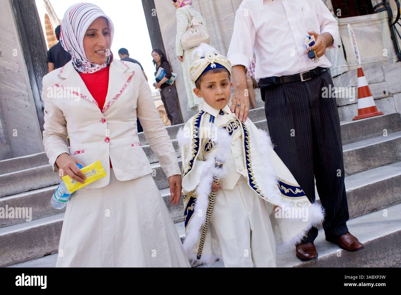 August 2007 - Istanbul, Türkei - Ein Junge in traditioneller „sŸnnet“-Uniform (Beschneidungskleidung) spaziert mit seiner Familie durch eine Moschee in Istanbul, Türkei. Türkische Jungen werden im Alter zwischen sieben und neun Jahren beschnitten. Die Beschneidung markiert den Übergang von der Kindheit zur Männlichkeit. Istanbul, eine Stadt mit etwa 14 Millionen Einwohnern und die größte Stadt der Türkei, liegt im Bosporus zwischen Europa und Asien. Es ist eine der ältesten Städte der Welt. Es war einst das Zentrum des Oströmischen Reiches und hieß Konstantinopel, benannt nach dem römischen Kaiser Konstantin. In Stockfoto