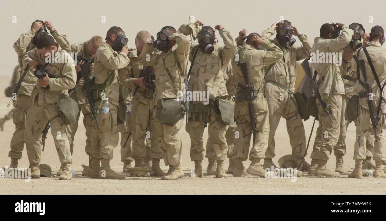(Veröffentlicht am 27.02.2003; A-12) Marines des 7. Marine-Regiments, die in der Schlange standen, um einen tragbaren Laden zu besuchen, versuchen, ihre Gasmasken anzuziehen, nachdem ein Alarm ausgelöst wurde, der auf einen chemischen Angriff hindeutet. Marine-Beamte sagten, dass einer der vielen Sensoren in der Gegend auf einen chemischen Angriff warnte, aber später von einem Team von Marines, das untersuchte, als „falsch positiv“ befunden wurde. SCHLÜSSELWÖRTER: CHEMIKALIEN. MILITÄR. Earnie Grafton/Union-Tribune8BIM Stockfoto