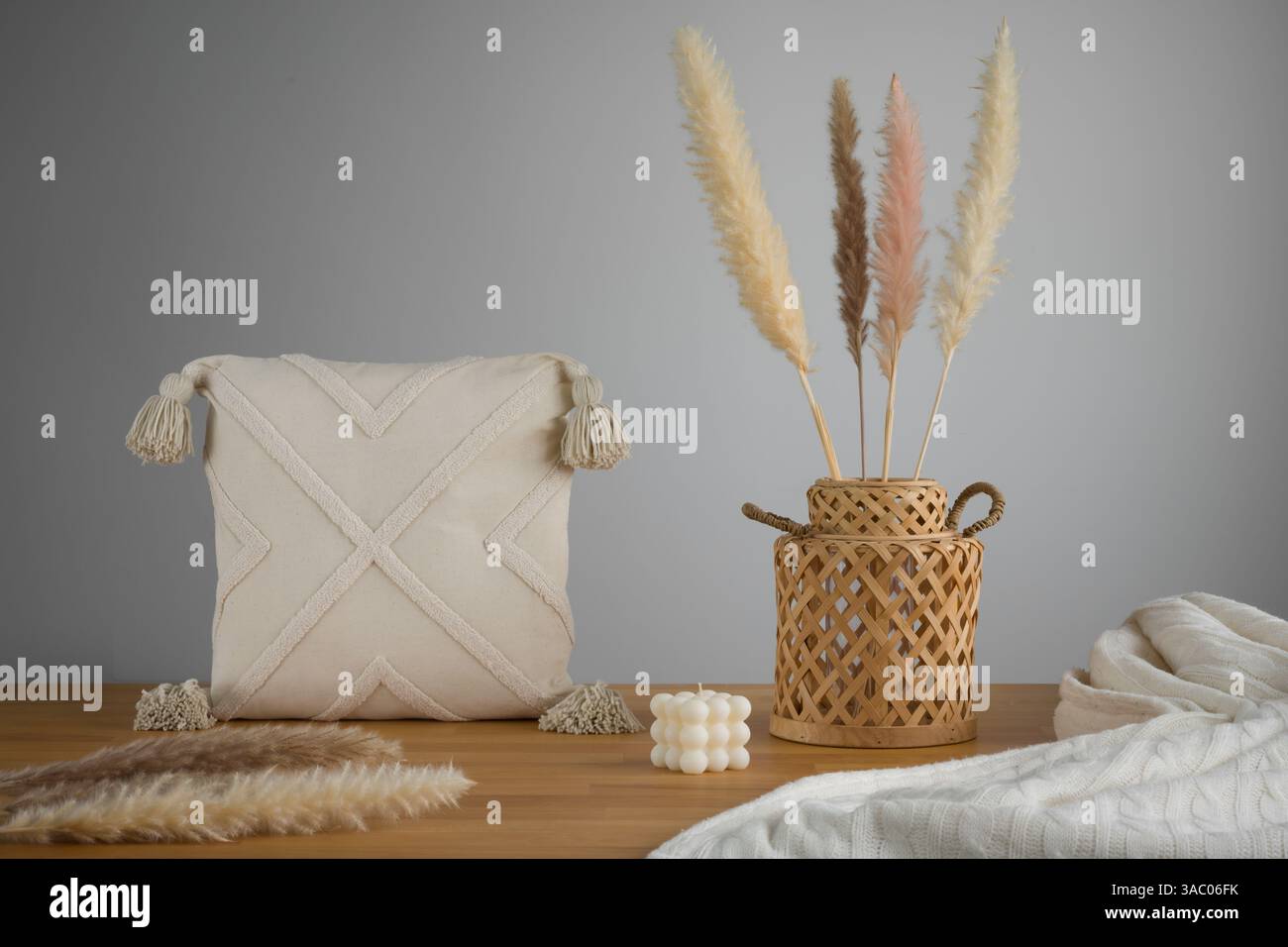 Boho-schicke Einrichtung: Strukturiertes Kissen und Pampas-Gras-Arrangement Stockfoto