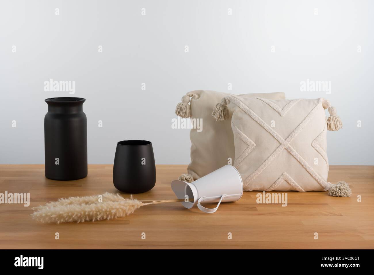 Minimalistische Inneneinrichtung: Schwarze Vasen und strukturierte Kissen zum Stillleben Stockfoto