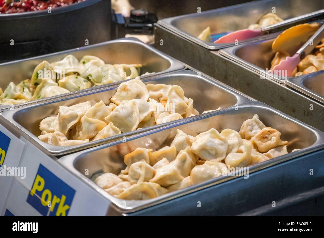Chinesische Pfannenknödel mit verschiedenen Füllungen auf dem Brick Lane Market in London Stockfoto