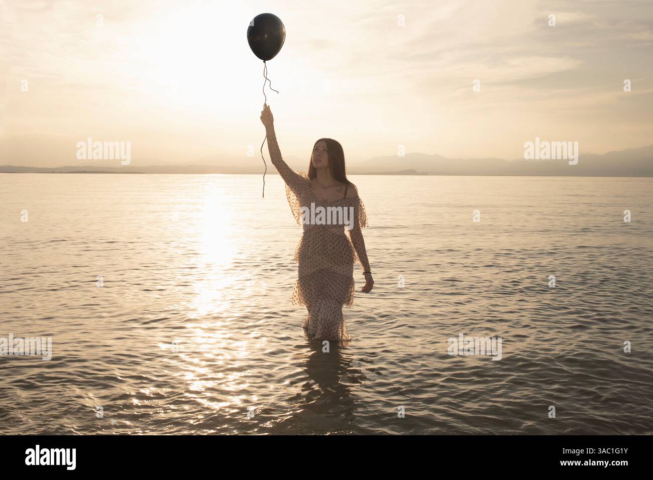 Frau mit schwarzem Ballon, die entkommen will, Freiheitsbegriff Stockfoto