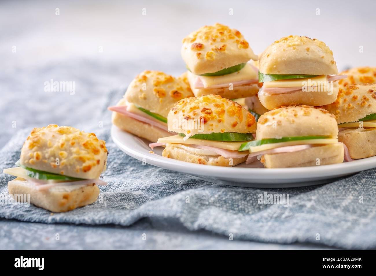 Kleine Sandwiches mit Schinken und Käse als Vorspeise auf einem Teller Stockfoto