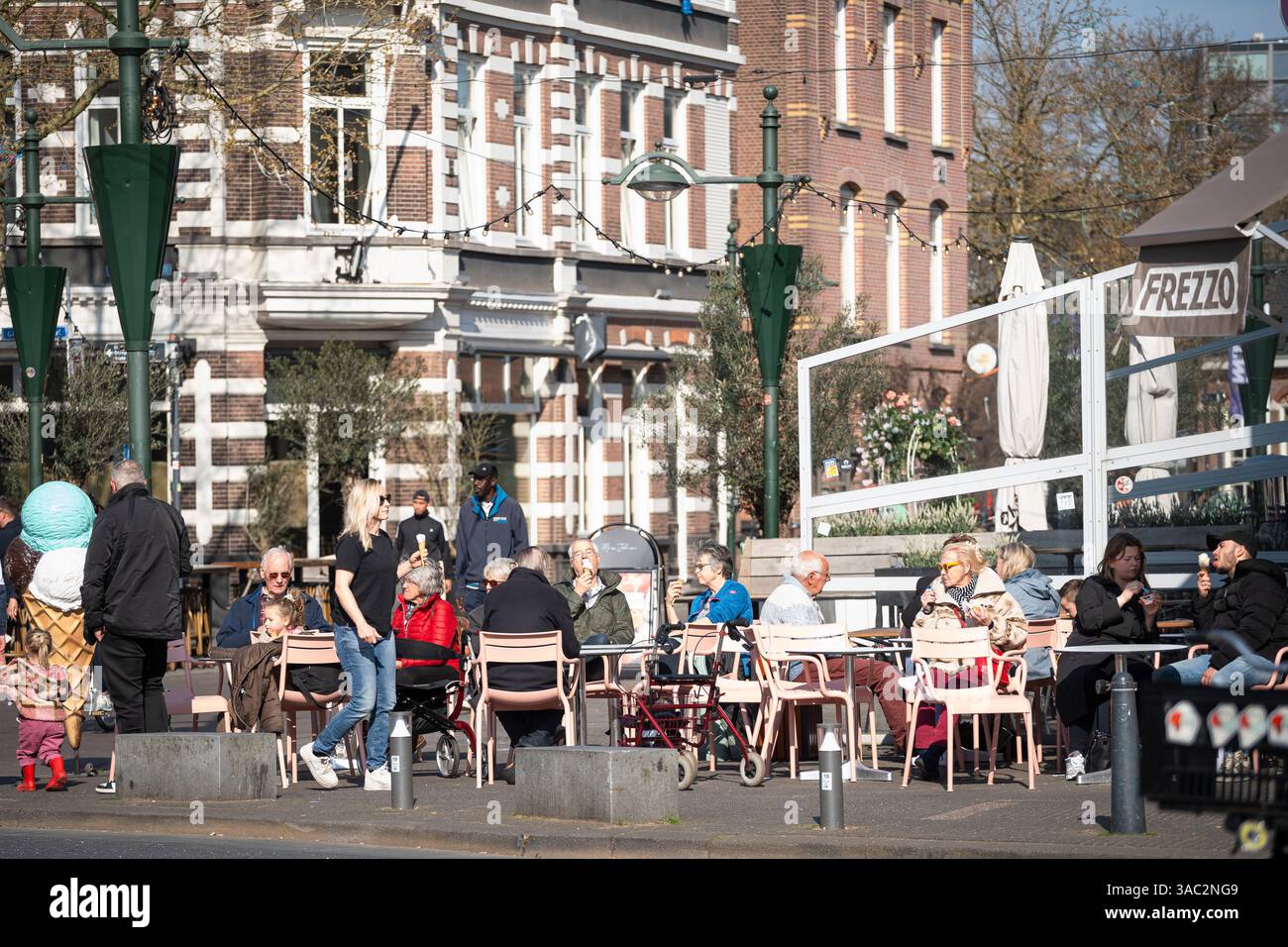 Menschen, die an einem sonnigen Frühlingstag auf der Terrasse Eiscreme trinken, Breda, Niederlande Stockfoto