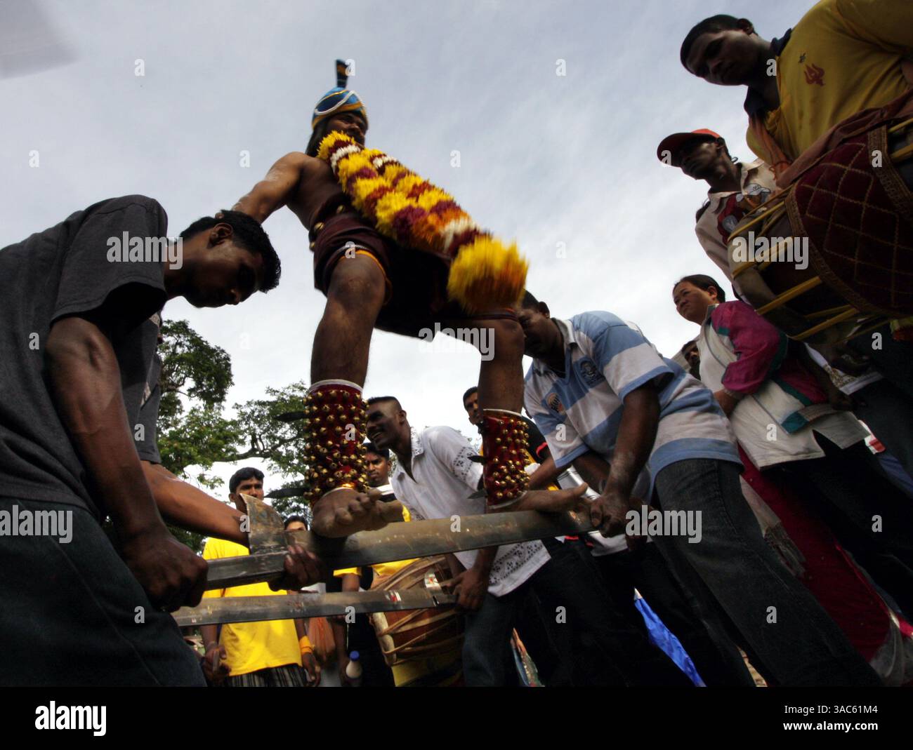 12. März 2008 - Kuala Lumpur, Malaysia - Thaipusam ist ein Hindu-Festival, das von der tamilischen Gemeinschaft weltweit am Vollmond im tamilischen Monat Thai gefeiert wird. Malaysische Gläubige bereiten sich auf das Ereignis vor, indem sie sich durch Gebet und Fasten reinigen. Fromme Teilnehmer durchstechen die Haut, Zunge oder Wangen mit Spießen. Es heißt, je größer der Schmerz, desto mehr Gott verdienten Verdienst. BILD am 23. Januar 2008: Ein Hindugeweihter geht auf einem scharfen Rasierer, während er sein Gebet während des Thaipusam Festivals vollbringt. (Kreditbild: Stockfoto