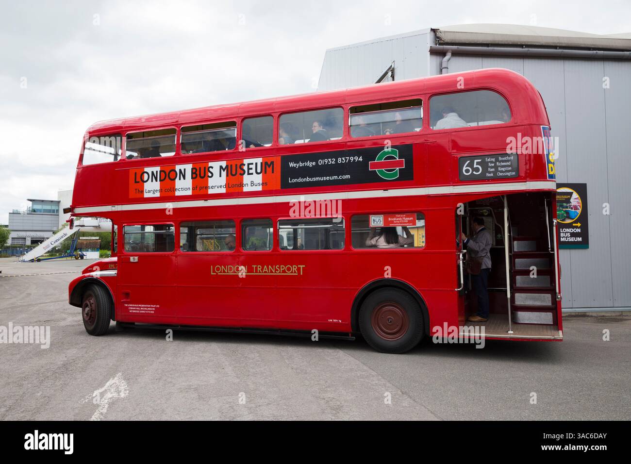 Roter Doppeldeckerbus mit der Nummer 65 routemaster und Besucher/Touristen im London Bus Museum Transport Museum in Brooklands in Weybridge. Surrey. UK. Das Überschallflugzeug Concorde steht hinter und ist für Touristen geöffnet. (139) Stockfoto