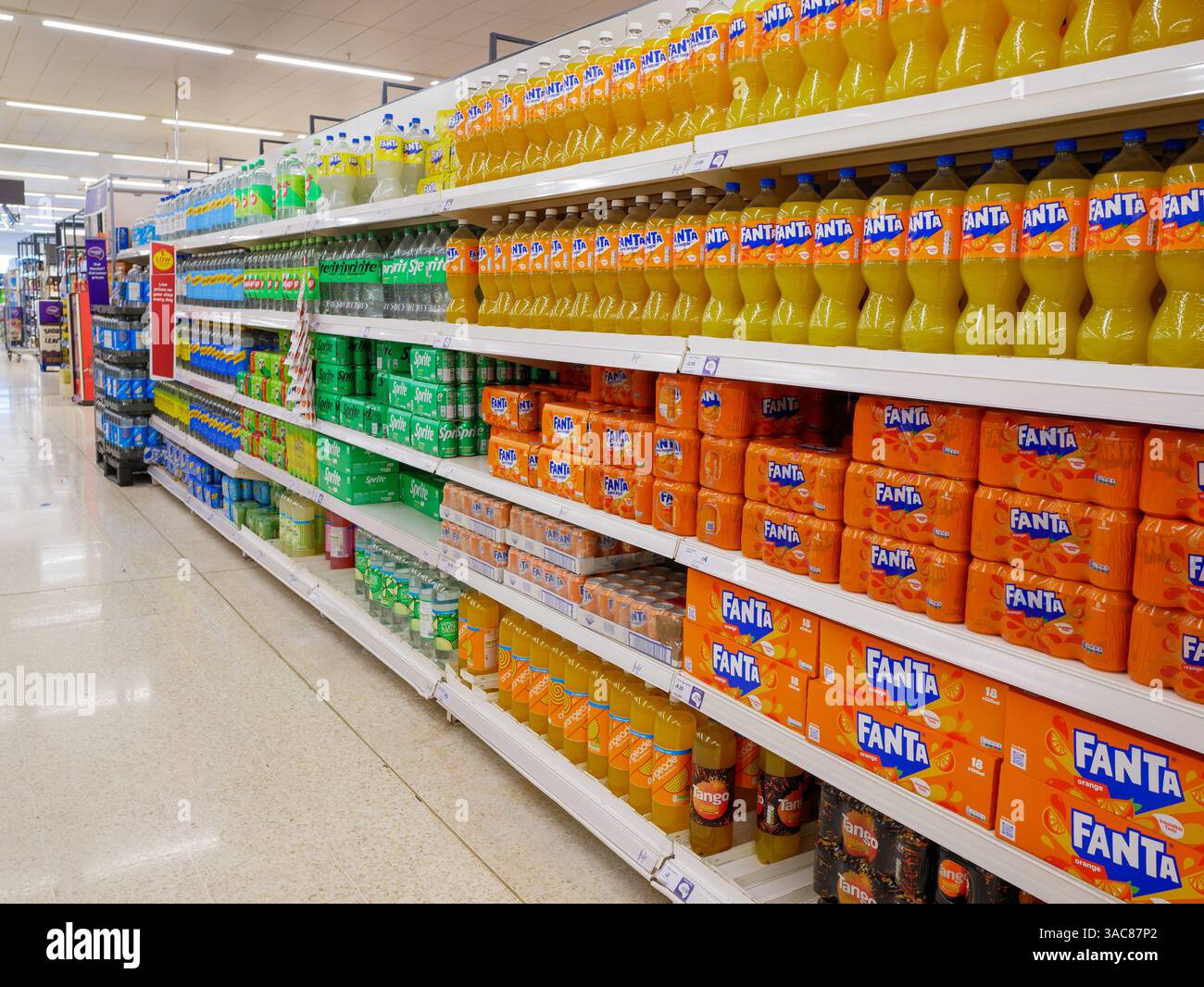 Alkoholfreie kohlensäurehaltige Getränke in den Regalen in Sainsbury's Supermarktgang, Großbritannien Stockfoto