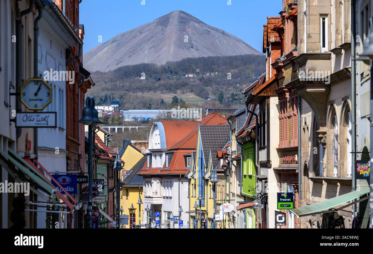 PRODUKTION - 02. April 2025, Sachsen-Anhalt, Sangerhausen: Zwischen den Häusern in der Altstadt von Sangerhausen erhebt sich der konische Schlackenhaufen hohe Linde, von weitem sichtbar. Der Schlackenhaufen stammt aus dem Abbau von Kupferschiefer. Die ersten Bergleute begannen vor 825 Jahren in der Region Mansfeld mit dem Graben nach Kupfererz. Ab 1750 wurde ein intensiver Bergbau durchgeführt. Insgesamt wurden rund 2,6 Millionen Tonnen Kupfer und 14.213 Tonnen Silber aus dem Erz in der Region gewonnen. Bis Dezember werden insgesamt 38 Veranstaltungen an den Beginn der Bergbau- und Hüttenwirtschaft in der Region Mansfeld erinnern. Als Ma Stockfoto