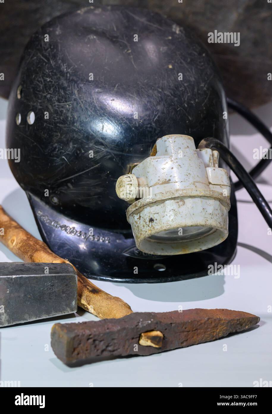 PRODUKTION - 02. April 2025, Sachsen-Anhalt, Sangerhausen: Die Utensilien eines Bergarbeiters, Hammer und Eisen, Fahrerhut und Scheinwerfer sind in der Ausstellung im Erlebniszentrum Bergbau Röhrigschacht Wettelrode zu sehen. Die ersten Bergleute begannen vor 825 Jahren in der Region Mansfeld mit dem Graben nach Kupfererz. Ab 1750 wurde ein intensiver Bergbau durchgeführt. Insgesamt wurden rund 2,6 Millionen Tonnen Kupfer und 14.213 Tonnen Silber aus dem Erz in der Region gewonnen. Bis Dezember werden insgesamt 38 Veranstaltungen an den Beginn der Bergbau- und Hüttenwirtschaft in der Region Mansfeld erinnern. Als Hauptkupfer und si Stockfoto