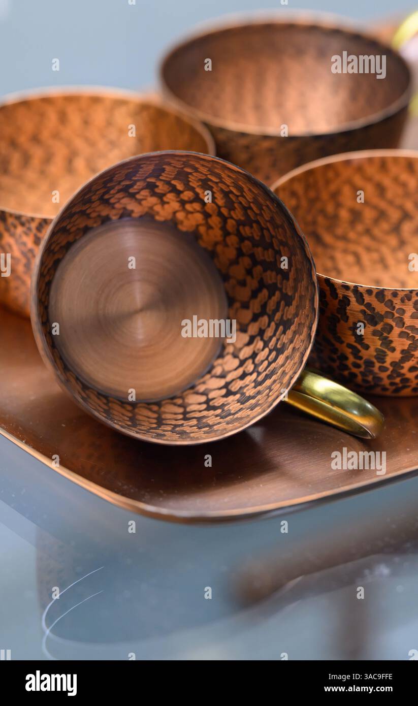 PRODUKTION - 02. April 2025, Sachsen-Anhalt, Sangerhausen: Ein Kupferkaffeeservice aus dem frühen 20. Jahrhundert ist in der Ausstellung im Erlebniszentrum Bergbau Röhrigschacht Wettelrode zu sehen. Die ersten Bergleute begannen vor 825 Jahren in der Region Mansfeld mit dem Graben nach Kupfererz. Ab 1750 wurde ein intensiver Bergbau durchgeführt. Insgesamt wurden rund 2,6 Millionen Tonnen Kupfer und 14.213 Tonnen Silber aus dem Erz in der Region gewonnen. Bis Dezember werden insgesamt 38 Veranstaltungen an den Beginn der Bergbau- und Hüttenwirtschaft in der Region Mansfeld erinnern. Als bedeutender Kupfer- und Silberproduzent Stockfoto