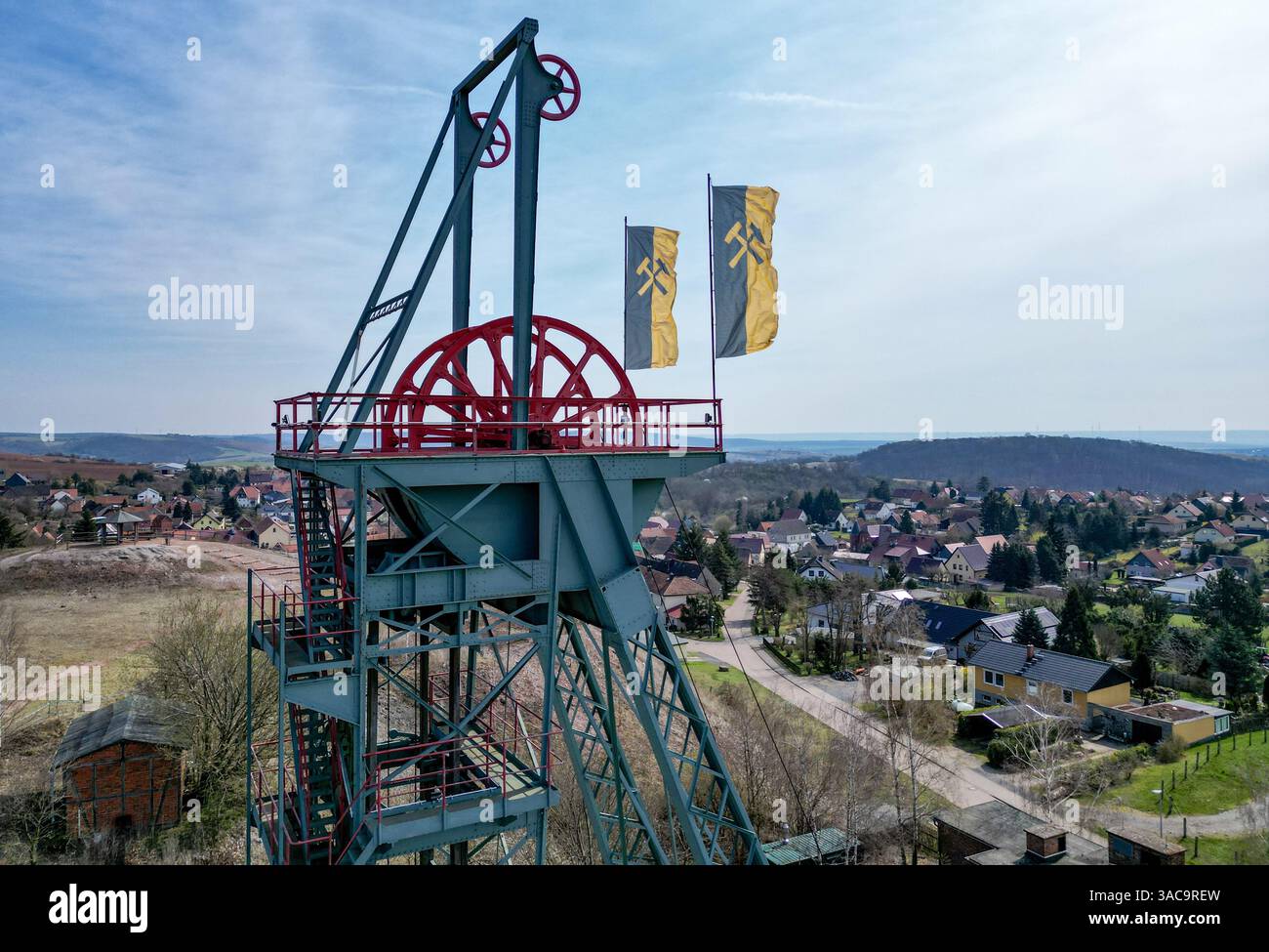 PRODUKTION - 02. April 2025, Sachsen-Anhalt, Sangerhausen: Der gewundene Turm erhebt sich auffallend über dem Erlebniszentrum Bergbau Röhrigschacht Wettelrode. (Foto mit Drohne) die ersten Bergleute begannen vor 825 Jahren in der Region Mansfeld nach Kupfererz zu graben. Ab 1750 wurde ein intensiver Bergbau durchgeführt. Insgesamt wurden rund 2,6 Millionen Tonnen Kupfer und 14.213 Tonnen Silber aus dem Erz in der Region gewonnen. Bis Dezember werden insgesamt 38 Veranstaltungen an den Beginn der Bergbau- und Hüttenwirtschaft in der Region Mansfeld erinnern. Als bedeutender Kupfer- und Silberproduzent ist die Region Contra Stockfoto