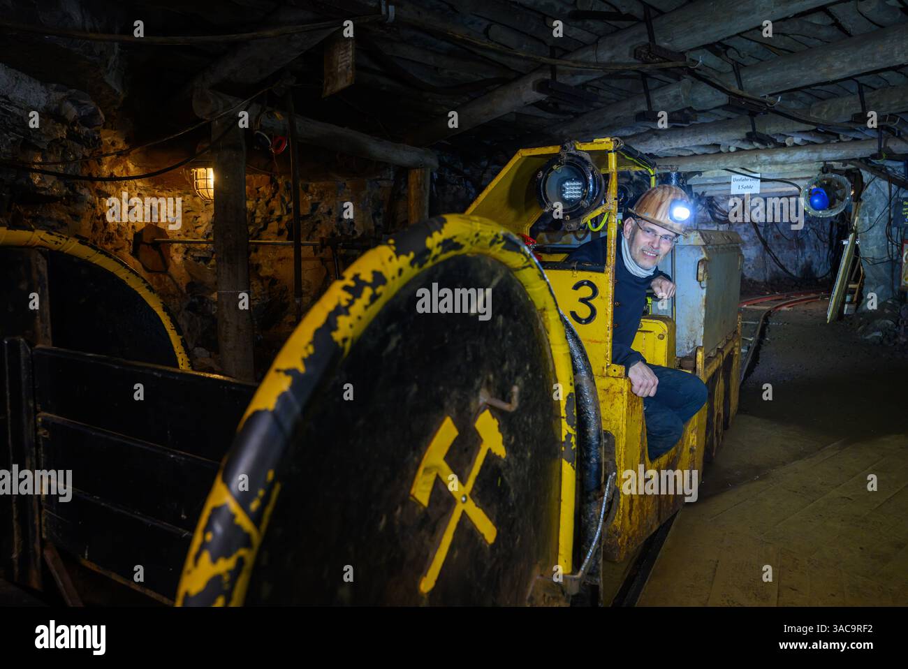 PRODUKTION - 02. April 2025, Sachsen-Anhalt, Sangerhausen: In fast 300 Metern Tiefe sitzt Thomas Wäsche, Direktor des Erlebniszentrums Bergbau Röhrigschacht Wettelrode, unterirdisch in der Grubenlokomotive. Die ersten Bergleute begannen vor 825 Jahren in der Region Mansfeld mit dem Graben nach Kupfererz. Ab 1750 wurde ein intensiver Bergbau durchgeführt. Insgesamt wurden rund 2,6 Millionen Tonnen Kupfer und 14.213 Tonnen Silber aus dem Erz in der Region gewonnen. Bis Dezember werden insgesamt 38 Veranstaltungen an den Beginn der Bergbau- und Hüttenwirtschaft in der Region Mansfeld erinnern. Als bedeutender Kupfer- und Silberpr Stockfoto