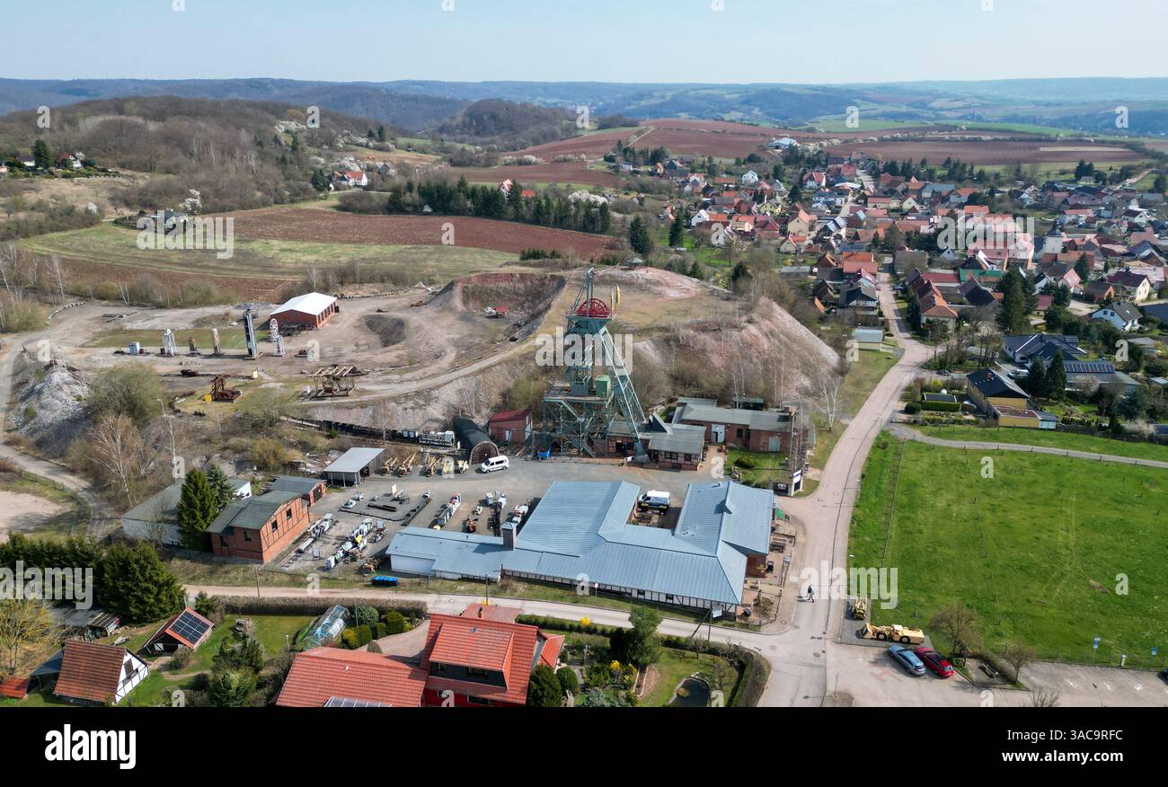 PRODUKTION - 02. April 2025, Sachsen-Anhalt, Sangerhausen: Der gewundene Turm erhebt sich auffallend über dem Erlebniszentrum Bergbau Röhrigschacht Wettelrode. (Foto mit Drohne) die ersten Bergleute begannen vor 825 Jahren in der Region Mansfeld nach Kupfererz zu graben. Ab 1750 wurde ein intensiver Bergbau durchgeführt. Insgesamt wurden rund 2,6 Millionen Tonnen Kupfer und 14.213 Tonnen Silber aus dem Erz in der Region gewonnen. Bis Dezember werden insgesamt 38 Veranstaltungen an den Beginn der Bergbau- und Hüttenwirtschaft in der Region Mansfeld erinnern. Als bedeutender Kupfer- und Silberproduzent ist die Region Contra Stockfoto