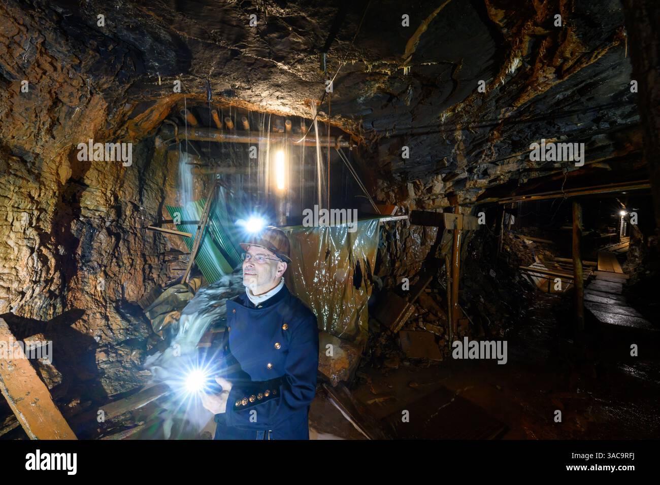 PRODUKTION - 02. April 2025, Sachsen-Anhalt, Sangerhausen: Thomas Wäsche, Direktor des Erlebniszentrums Bergbau Röhrigschacht Wettelrode, steht fast 300 Meter unter der Erde. Die ersten Bergleute begannen vor 825 Jahren in der Region Mansfeld mit dem Graben nach Kupfererz. Ab 1750 wurde ein intensiver Bergbau durchgeführt. Insgesamt wurden rund 2,6 Millionen Tonnen Kupfer und 14.213 Tonnen Silber aus dem Erz in der Region gewonnen. Bis Dezember werden insgesamt 38 Veranstaltungen an den Beginn der Bergbau- und Hüttenwirtschaft in der Region Mansfeld erinnern. Als bedeutender Kupfer- und Silberproduzent ist die Region ein wichtiger Faktor Stockfoto