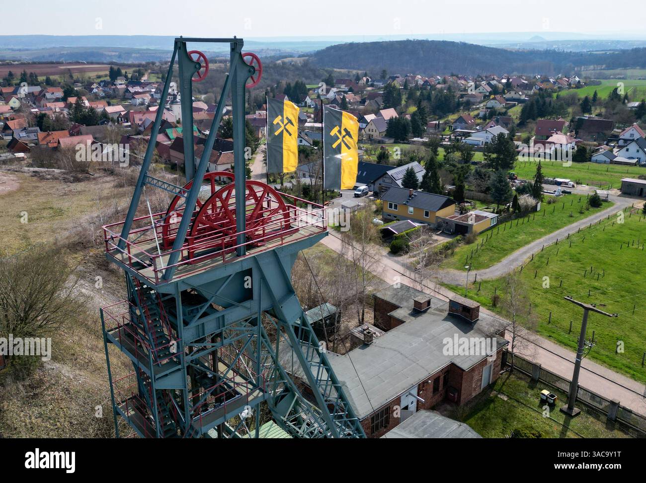 PRODUKTION - 02. April 2025, Sachsen-Anhalt, Sangerhausen: Der gewundene Turm erhebt sich auffallend über dem Erlebniszentrum Bergbau Röhrigschacht Wettelrode. (Foto mit Drohne) die ersten Bergleute begannen vor 825 Jahren in der Region Mansfeld nach Kupfererz zu graben. Ab 1750 wurde ein intensiver Bergbau durchgeführt. Insgesamt wurden rund 2,6 Millionen Tonnen Kupfer und 14.213 Tonnen Silber aus dem Erz in der Region gewonnen. Bis Dezember werden insgesamt 38 Veranstaltungen an den Beginn der Bergbau- und Hüttenwirtschaft in der Region Mansfeld erinnern. Als bedeutender Kupfer- und Silberproduzent ist die Region Contra Stockfoto