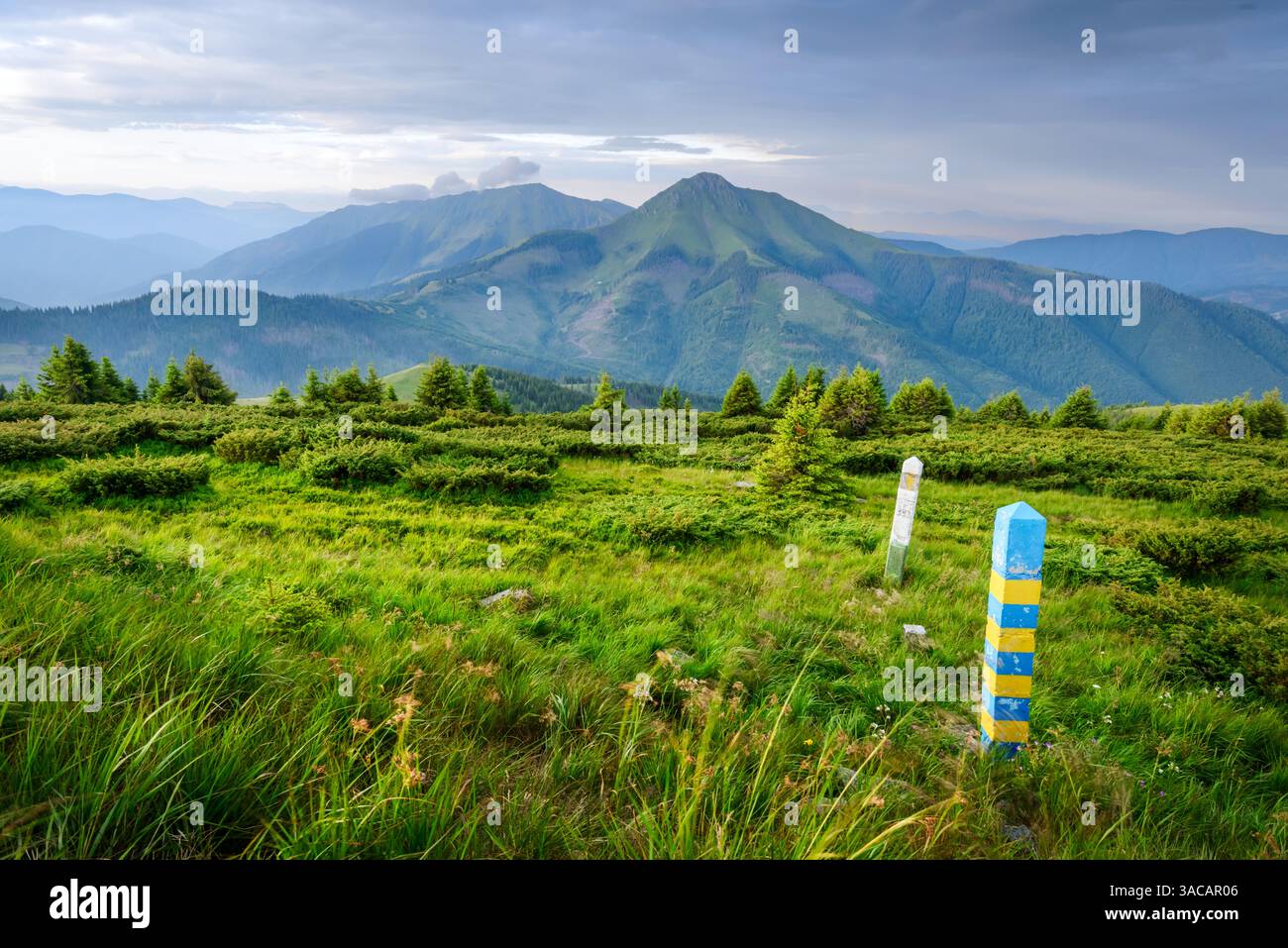 Blick auf die Staatsgrenze der Ukraine und Rumäniens in den Karpaten. Gelbe und blaue Grenzposten in Maramures, Ukraine, Europa Stockfoto