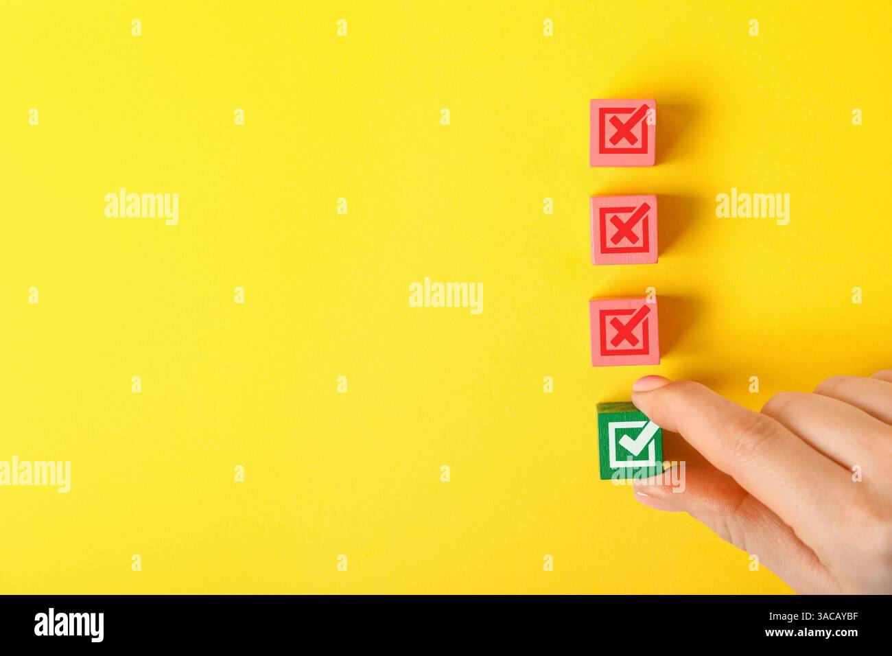 Genehmigt. Frau, die einen Würfel mit Häkchen wählt, unter anderem mit Kreuzen auf gelbem Hintergrund, Draufsicht Stockfoto