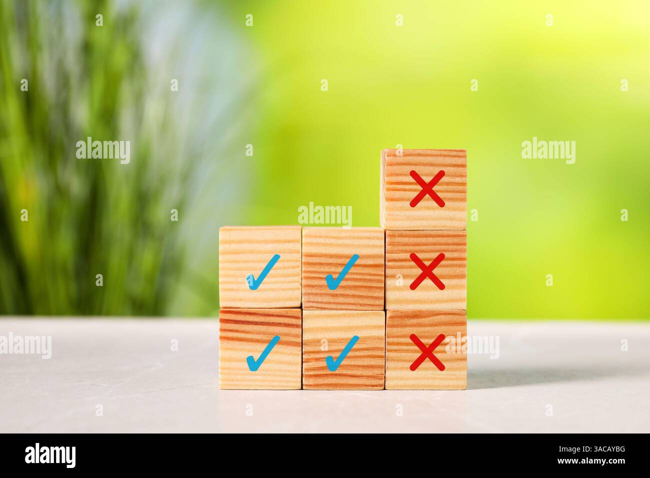 Ablehnung genehmigen. Holzwürfel mit Check- und Kreuzmarkierungen auf dem Tisch Stockfoto