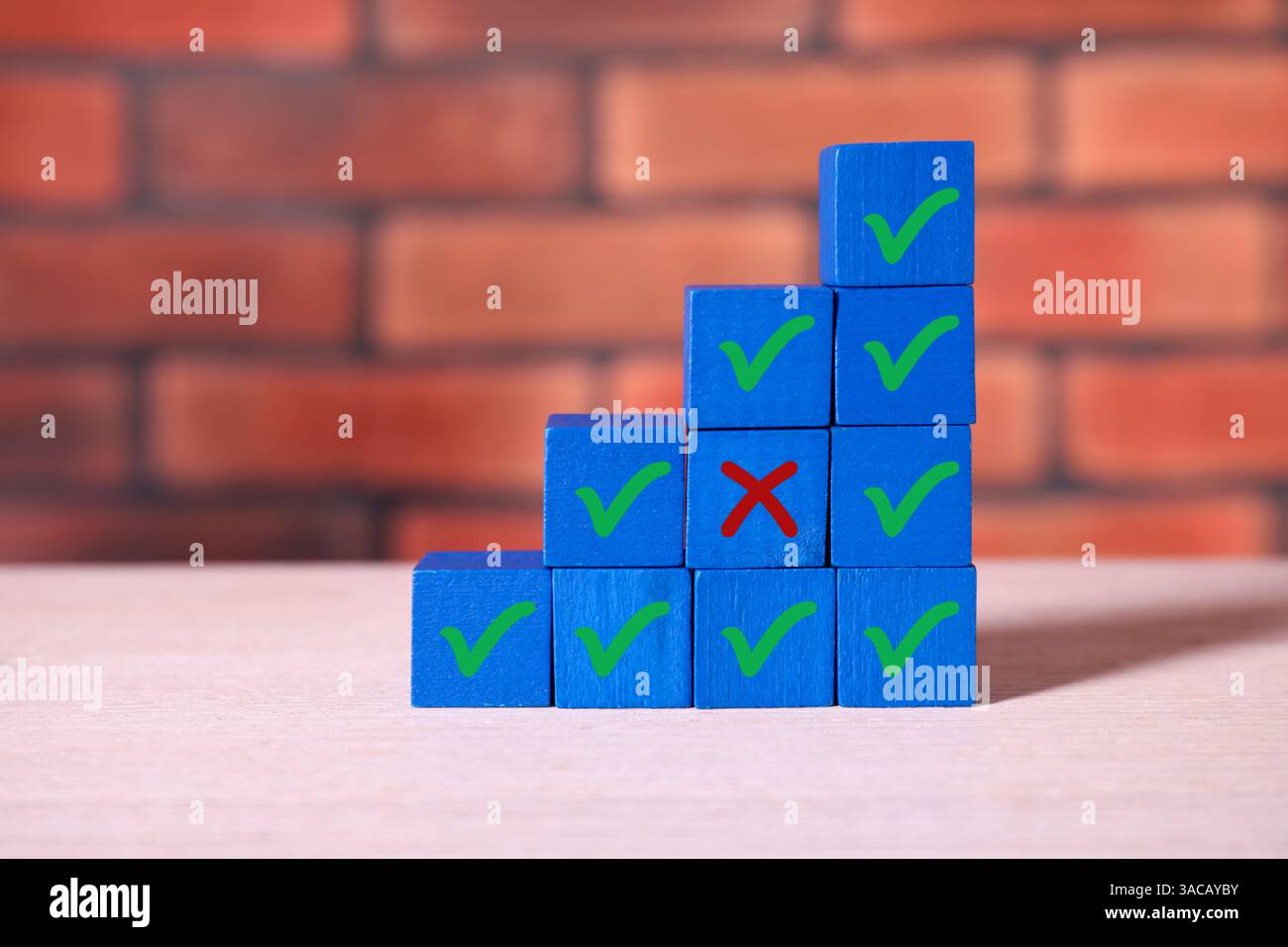 Ablehnung genehmigen. Holzwürfel mit Check- und Kreuzmarkierungen auf dem Tisch Stockfoto