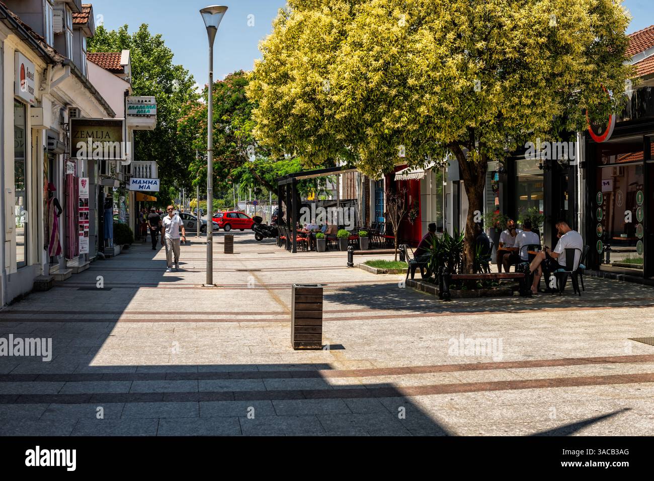Podgorica, Montenegro - 29. Juni 2023: Menschen gehen an Geschäften vorbei und essen im Sommer in der Njegoseva Straße in der Innenstadt von Nova Varos Stockfoto
