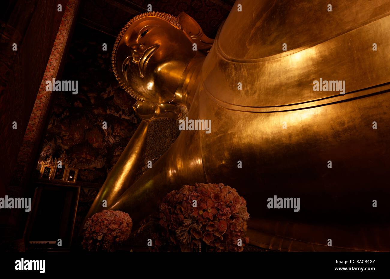 Ein genauerer Blick auf das anmutige Gesicht und die vergoldete Form des liegenden Buddha im Wat Pho Stockfoto