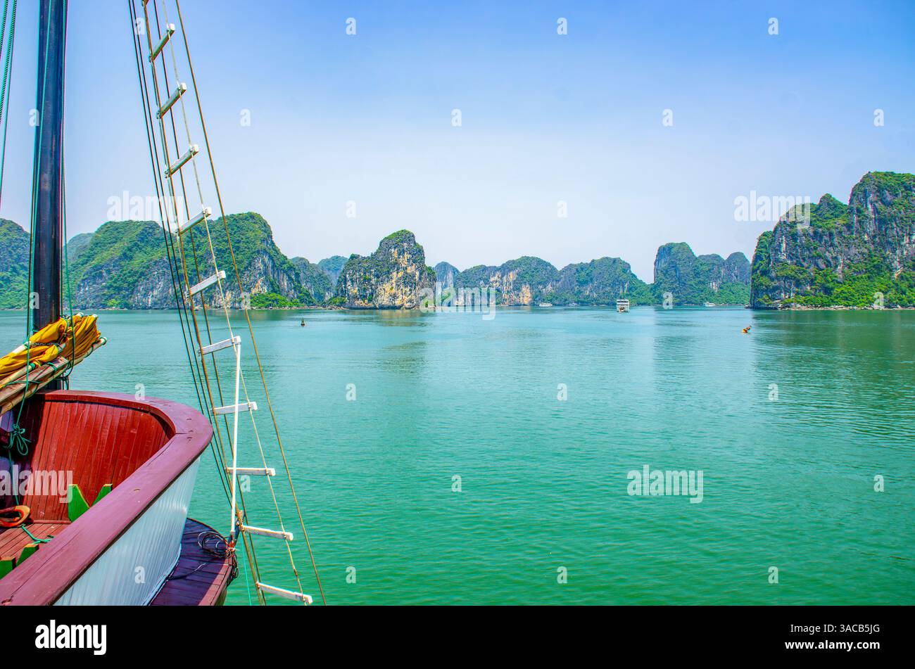Ha Long Bay, Vietnam. Weitwinkelblick auf das Hotelboot zwischen Kalksteinkarsten und Inselchen des UNESCO-Weltkulturerbes. Stockfoto