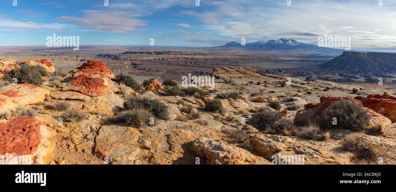 Die schneebedeckten Henry Mountains erheben sich über den bunten, zerklüfteten Utah Badlands und erinnern daran, dass der Winter in der Wüste Utahs angekommen ist. Stockfoto