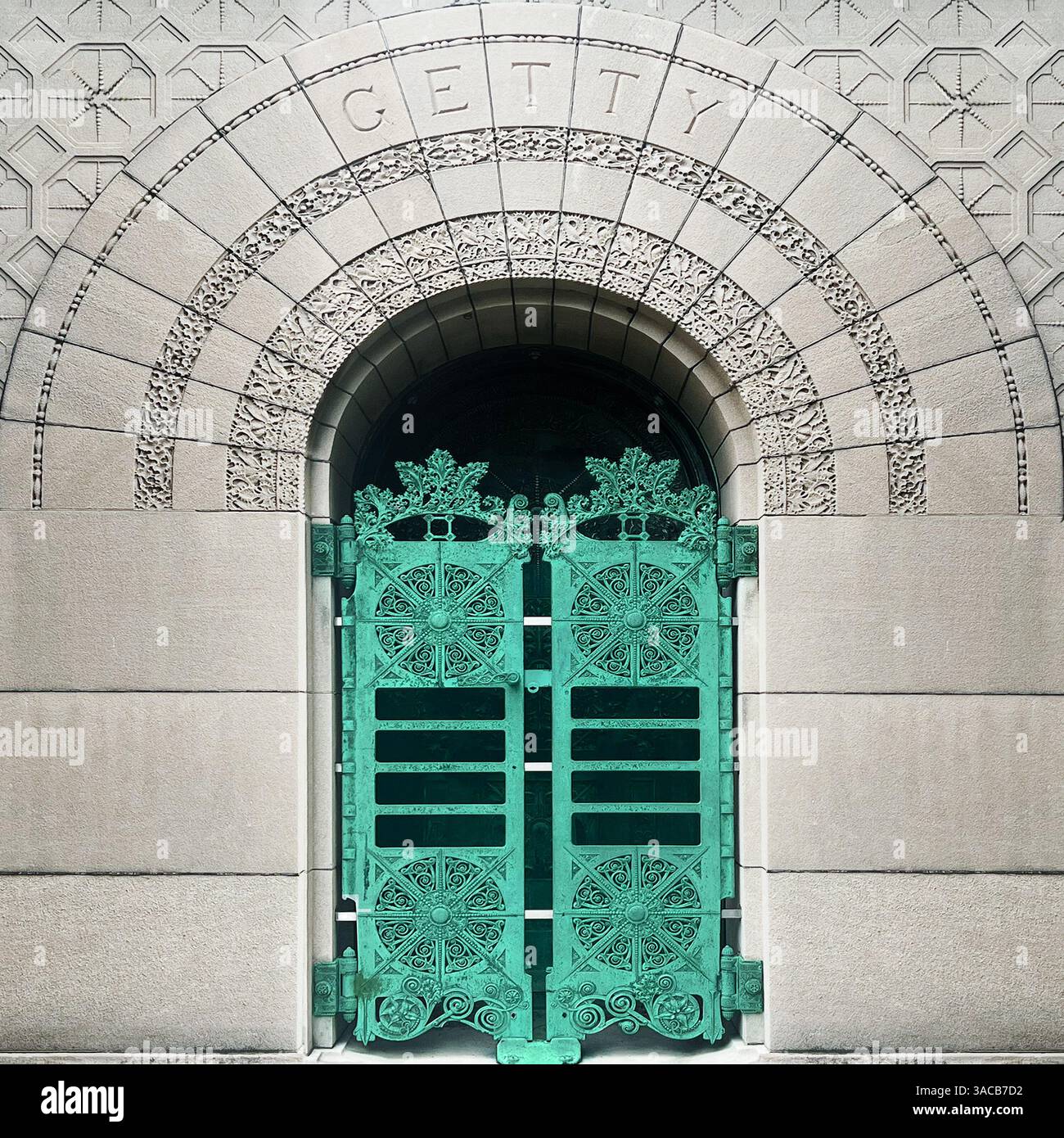 Das Gatesto Getty ist aus grüner Bronze, eingerahmt von komplizierten Steinschnitzereien und romanischen Bogendesigns auf einem historischen Friedhof in Chicago - Smartphone-aufgenommenes Stockfoto