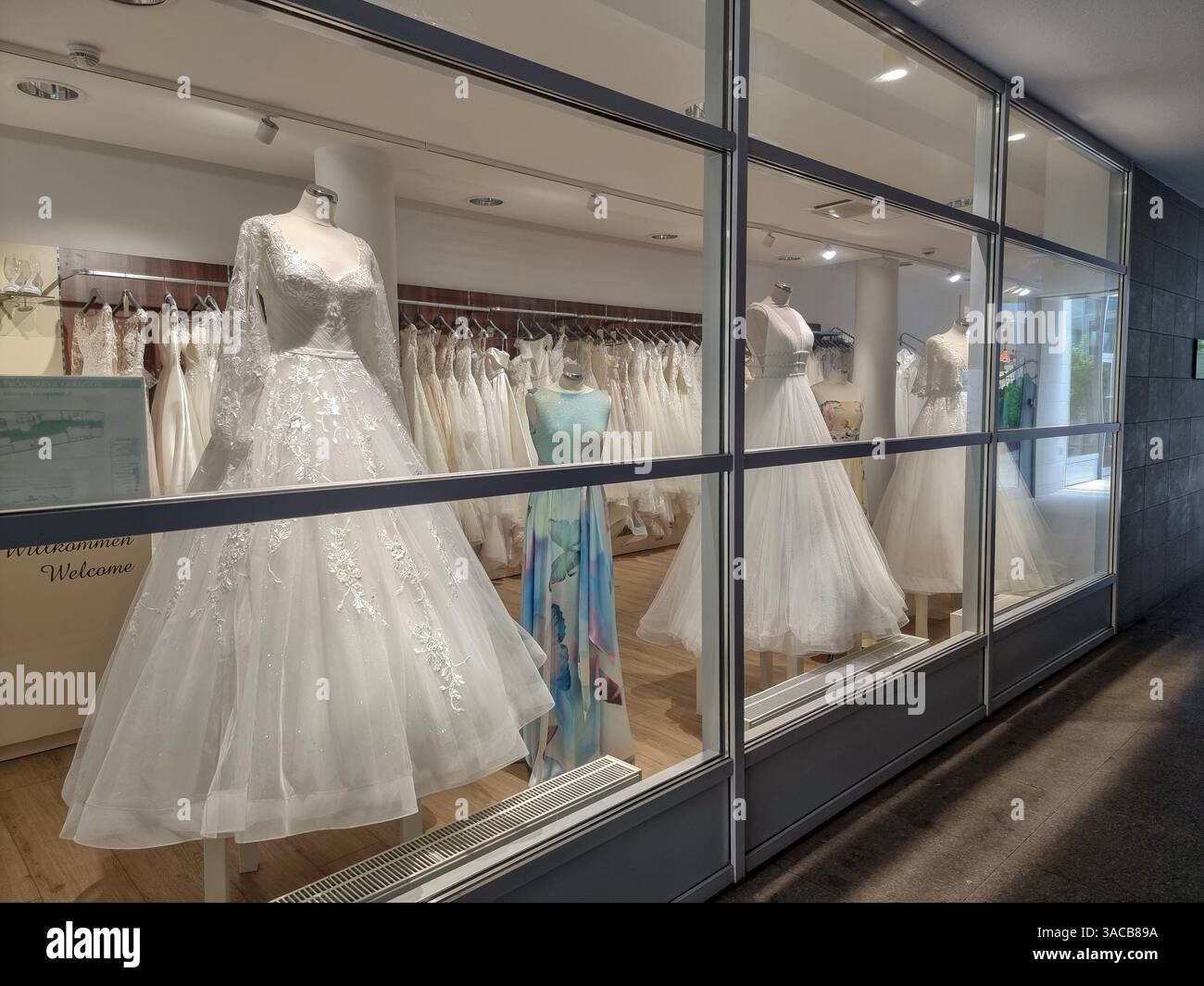 Schaufenster eines Brautmodengeschäfts mit Schaufensterpuppen in weißen Brautkleidern Stockfoto