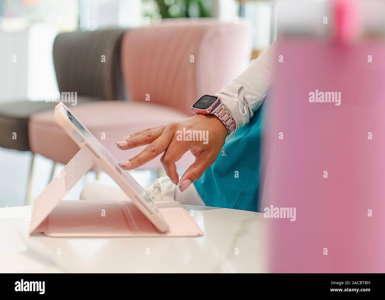 Eine Frau in Krankenschwesteruniform benutzt eine Tablette im Elkins Park, Pennsylvania, USA, 3. April 2025 Stockfoto