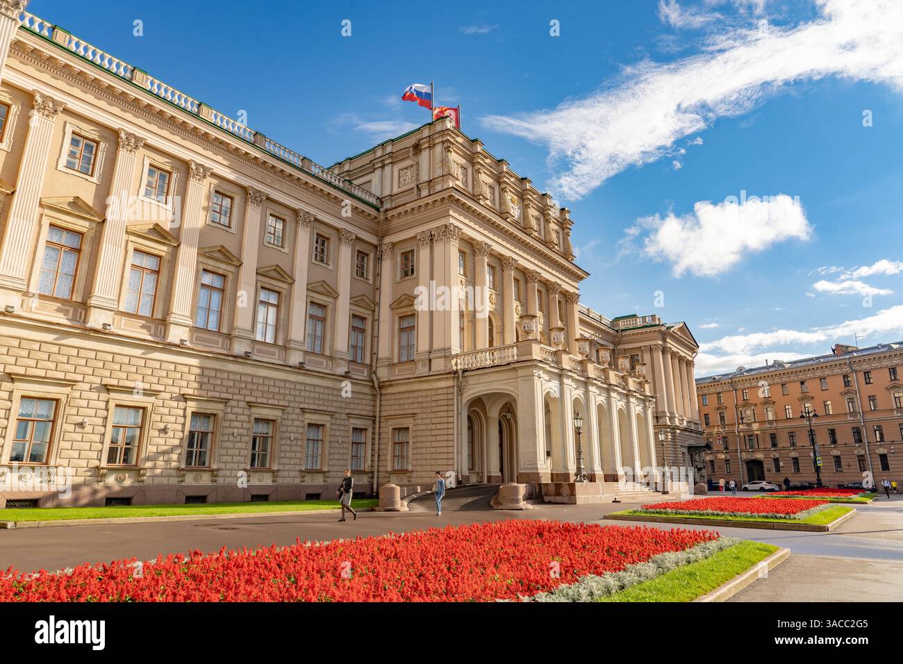 Russland, St. Petersburg - 9. August 2020: Yusupow-Palast im Sonnenlicht, elegante Fassade mit roten Akzenten, ergänzt durch russische Flagge, die gegen sie winkt Stockfoto