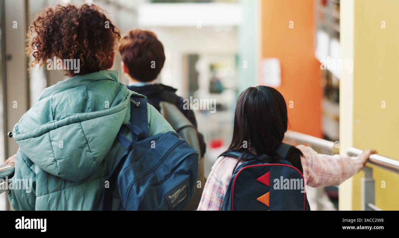 Zurück, Gehen und Schüler in der Schule für Bildung, Wissen oder Zukunft mit Entwicklung. Tasche, Lernen und Gruppe von Kindern auf dem Campus am Morgen für Stockfoto