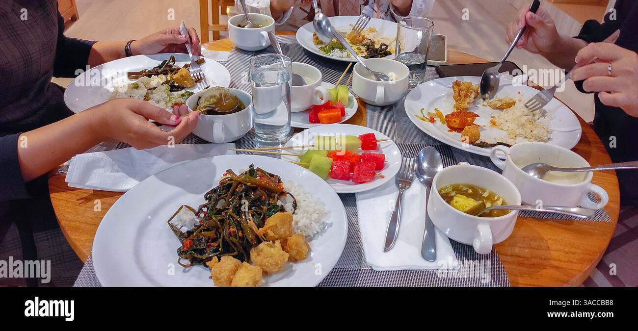Gemeinsame Mahlzeit mit Reis, Suppe und lebendigen Obstspießen, die ein gemeinsames kulinarisches Erlebnis mit frischen, gesunden Speisen hervorheben Stockfoto