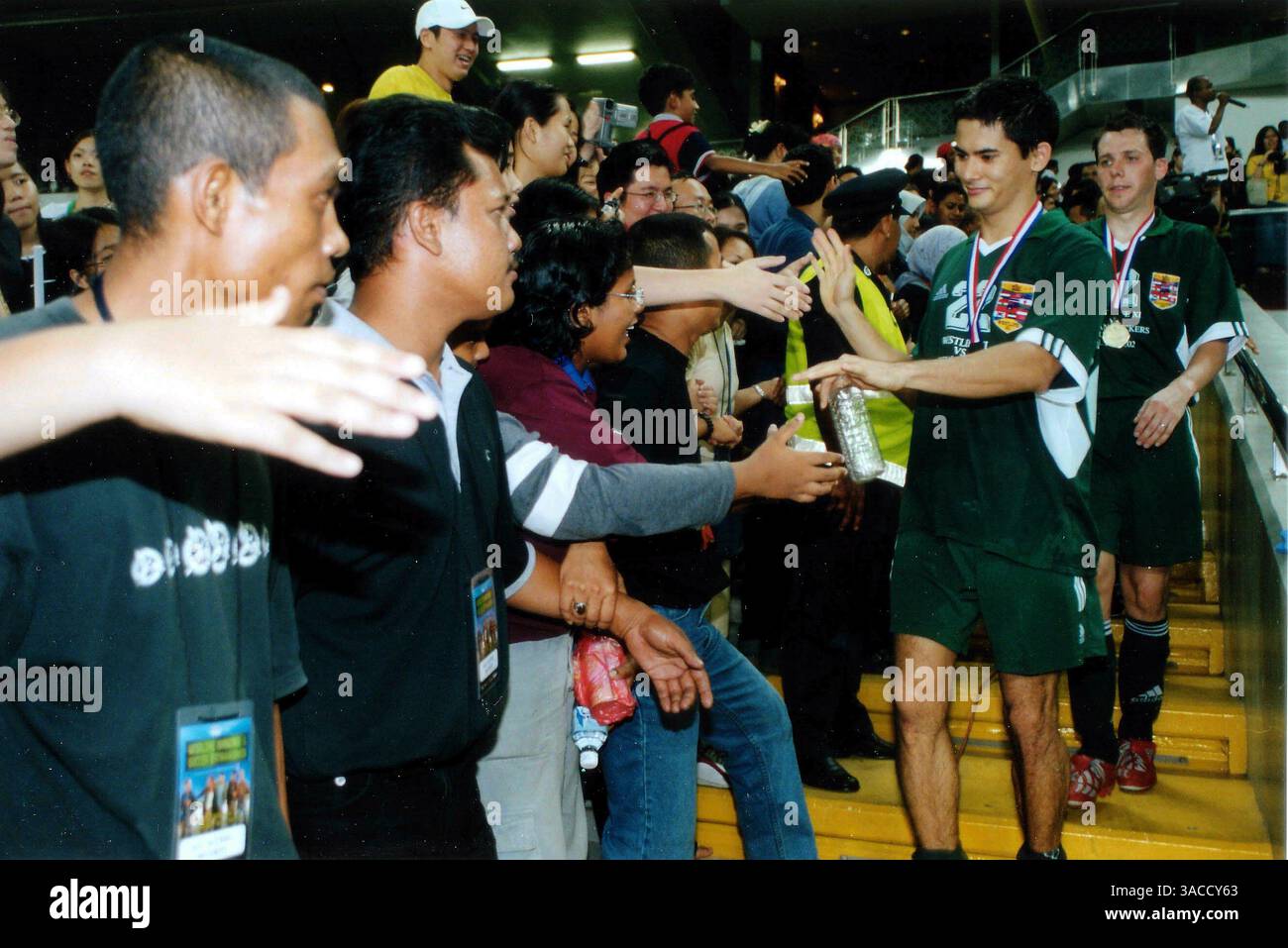 Alex Yoong (mal) unterschreibt Autogramme für Fans nach einem Benefizfußballspiel mit der irischen Boyband Westlife. WESTLIFE, bestehend aus Kian Egan, Nicky Byrne, Bryan McFadden, Shane Filan und Mark Feehily, war für einen dreitägigen Besuch in Malaysia, um ihr neuestes Album, eine Compilation mit dem Titel Unbreakable, zu promoten. Dies ist das erste Land in Asien, das von der Band besucht wird. Die Fans wurden durch ein kurzes Konzert unterhalten und spielten Fußball für eine lokale Wohltätigkeitsorganisation. Das spannende Fußballspiel bestand auch aus Formel-1-Fahrer Alex Yoong und anderen lokalen Prominenten. Charity Football Match, Mala Stockfoto