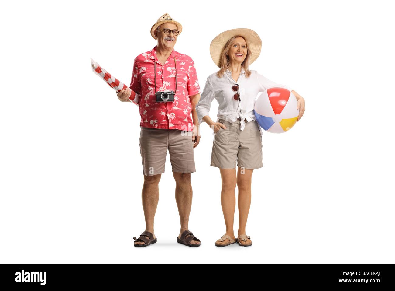 Glücklicher reifer Mann und Frau Tourist, der einen Sonnenschirm und eine Kugel auf weißem Hintergrund hält Stockfoto