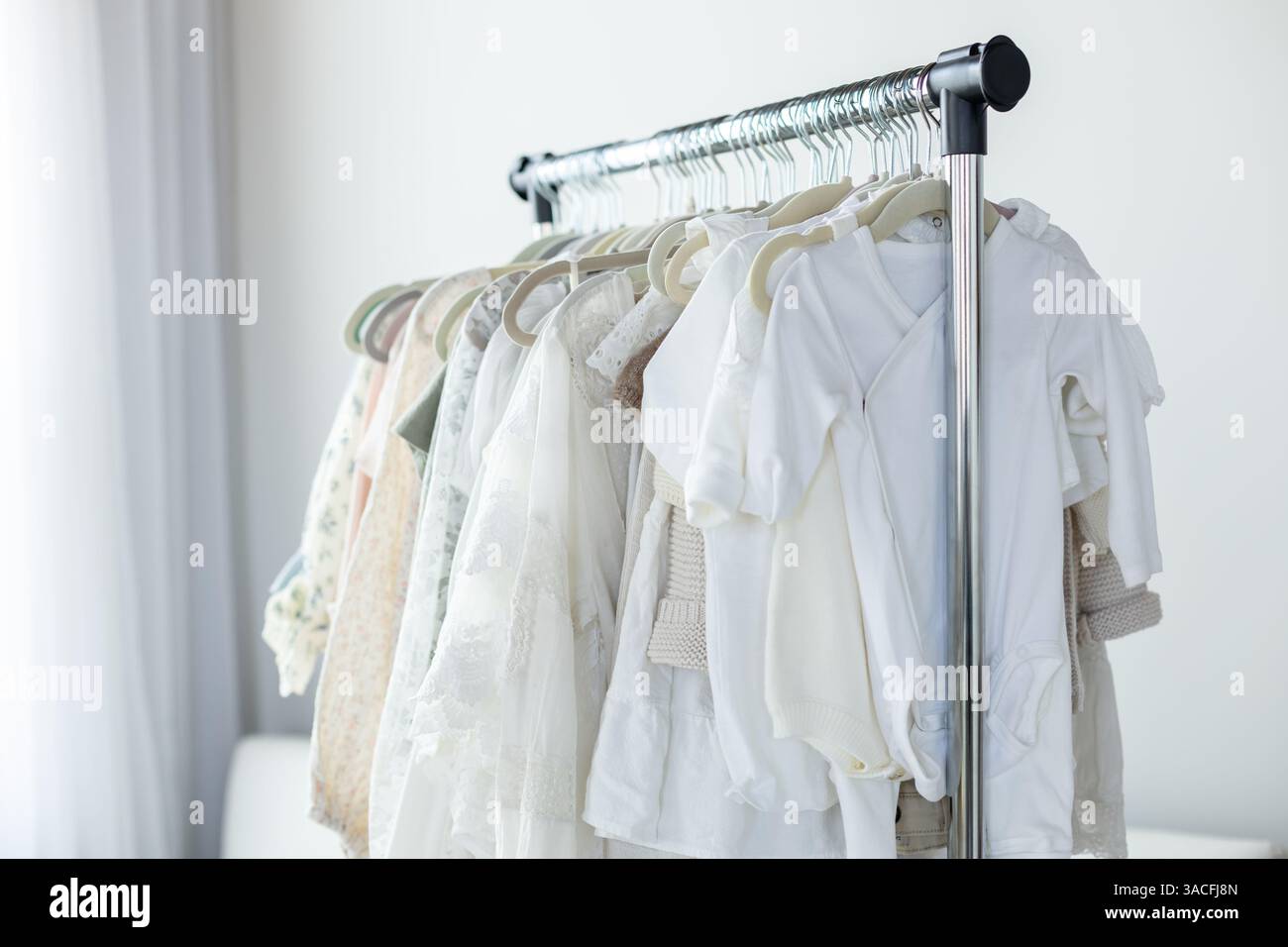 Kleiderständer mit neutralen Kleidungsstücken Stockfoto
