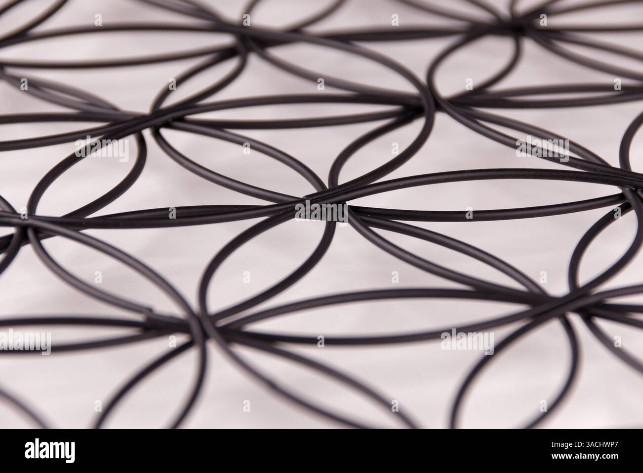 Schwarze Struktur auf weißem Hintergrund mit Blume des Lebens Symbol, heilige Geometrie oder Zen Symbol, Nahaufnahme Bild Stockfoto