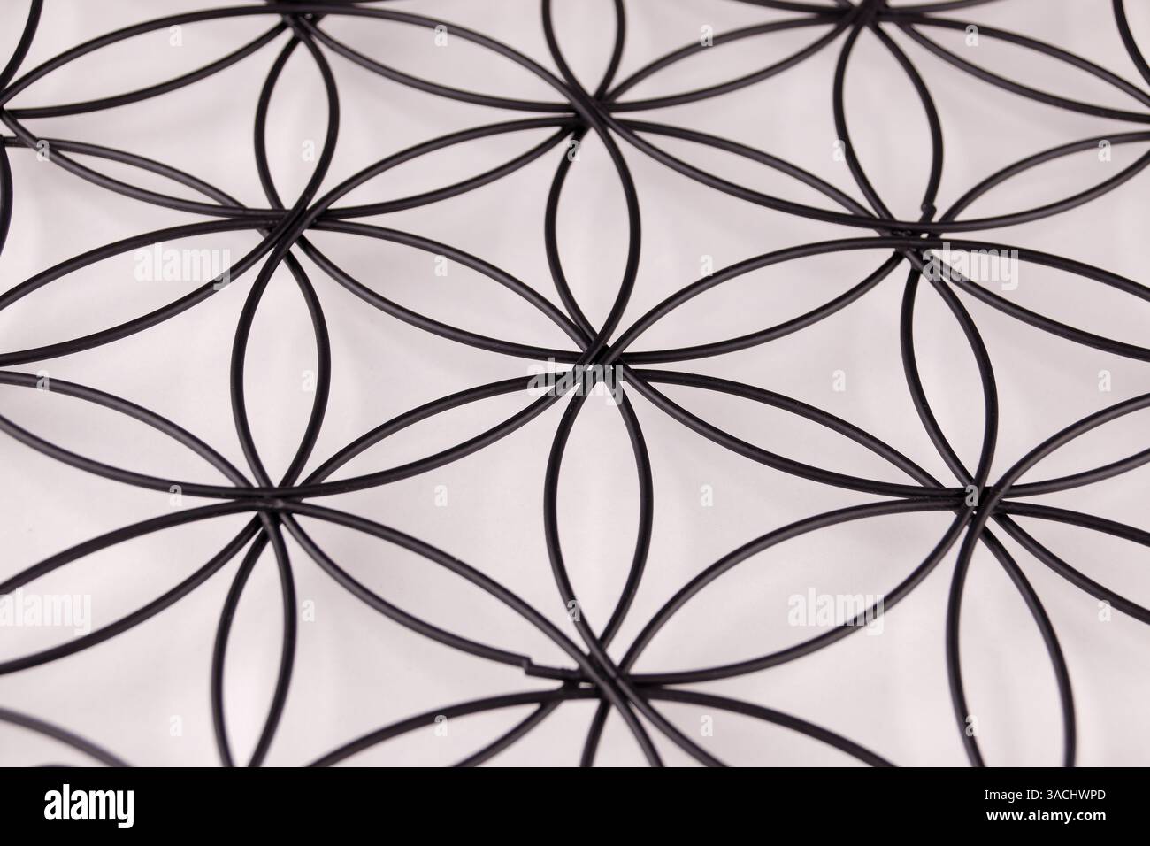 Schwarze Struktur auf weißem Hintergrund mit Blume des Lebens Symbol, heilige Geometrie oder Zen Symbol, Nahaufnahme Bild Stockfoto