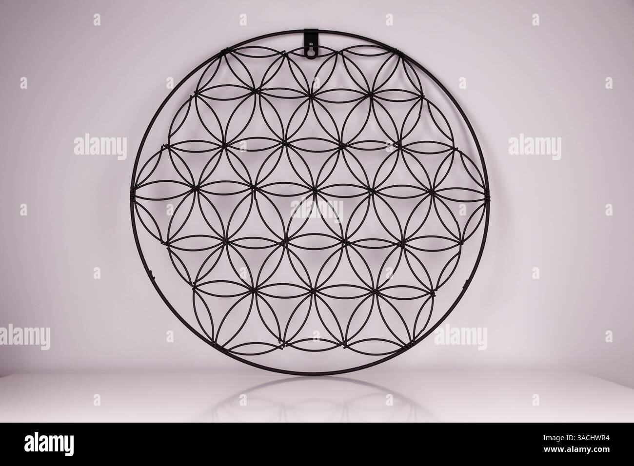 Schwarze Struktur auf weißem Hintergrund mit Blume des Lebens Symbol, heilige Geometrie oder Zen Symbol, Nahaufnahme Bild Stockfoto