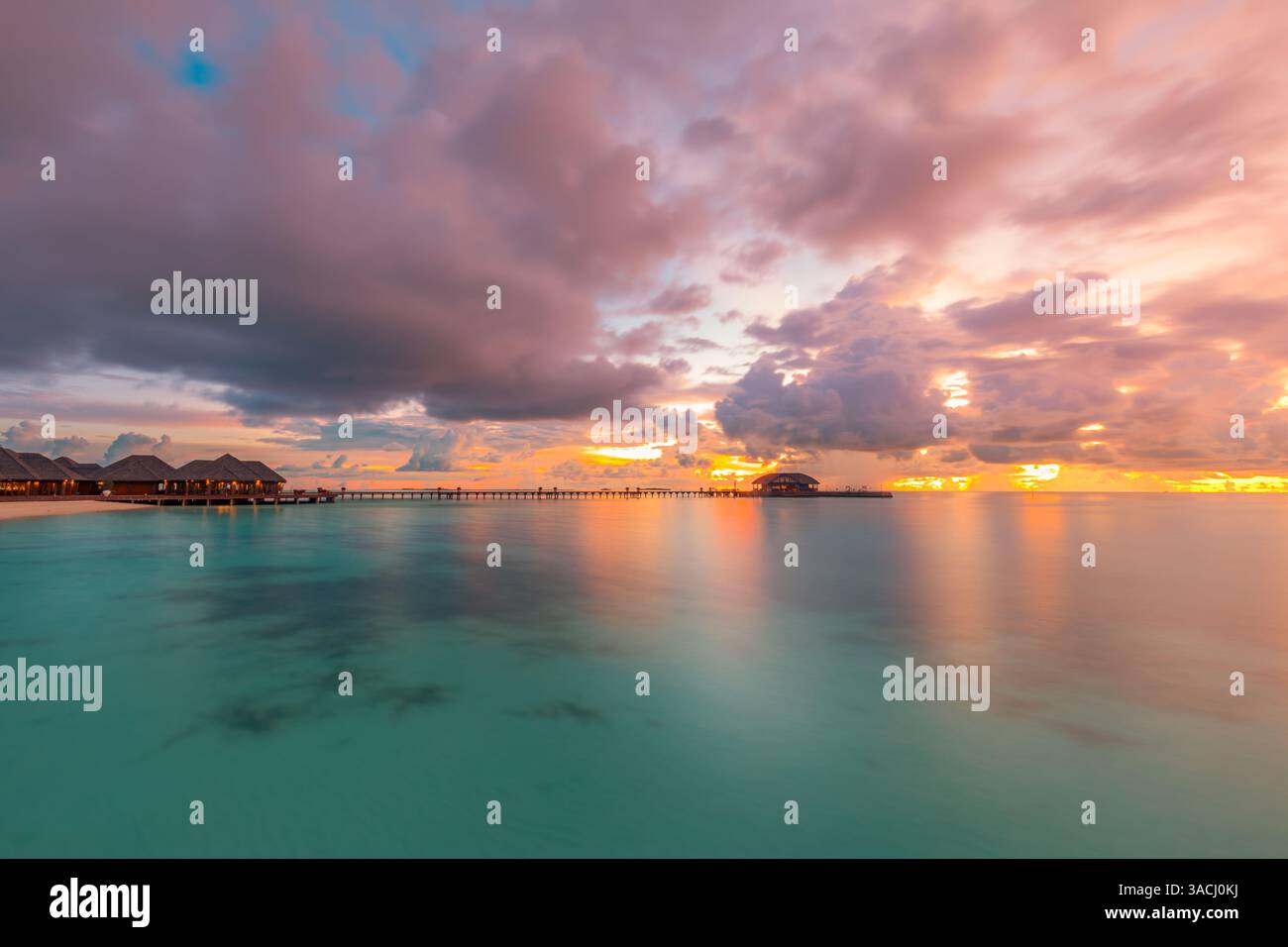 Atemberaubender Sonnenuntergang auf den Malediven. Ruhige Uferlandschaft mit goldenem Himmel, ruhigem Meer, Palmen Strand. Perfekter Sommerurlaub ins tropische Paradies Stockfoto