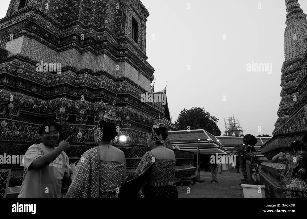 Künstler in traditioneller thailändischer Kleidung bereiten sich auf ein Fotoshooting unter den komplizierten Türmen des Tempels Wat Pho vor Stockfoto