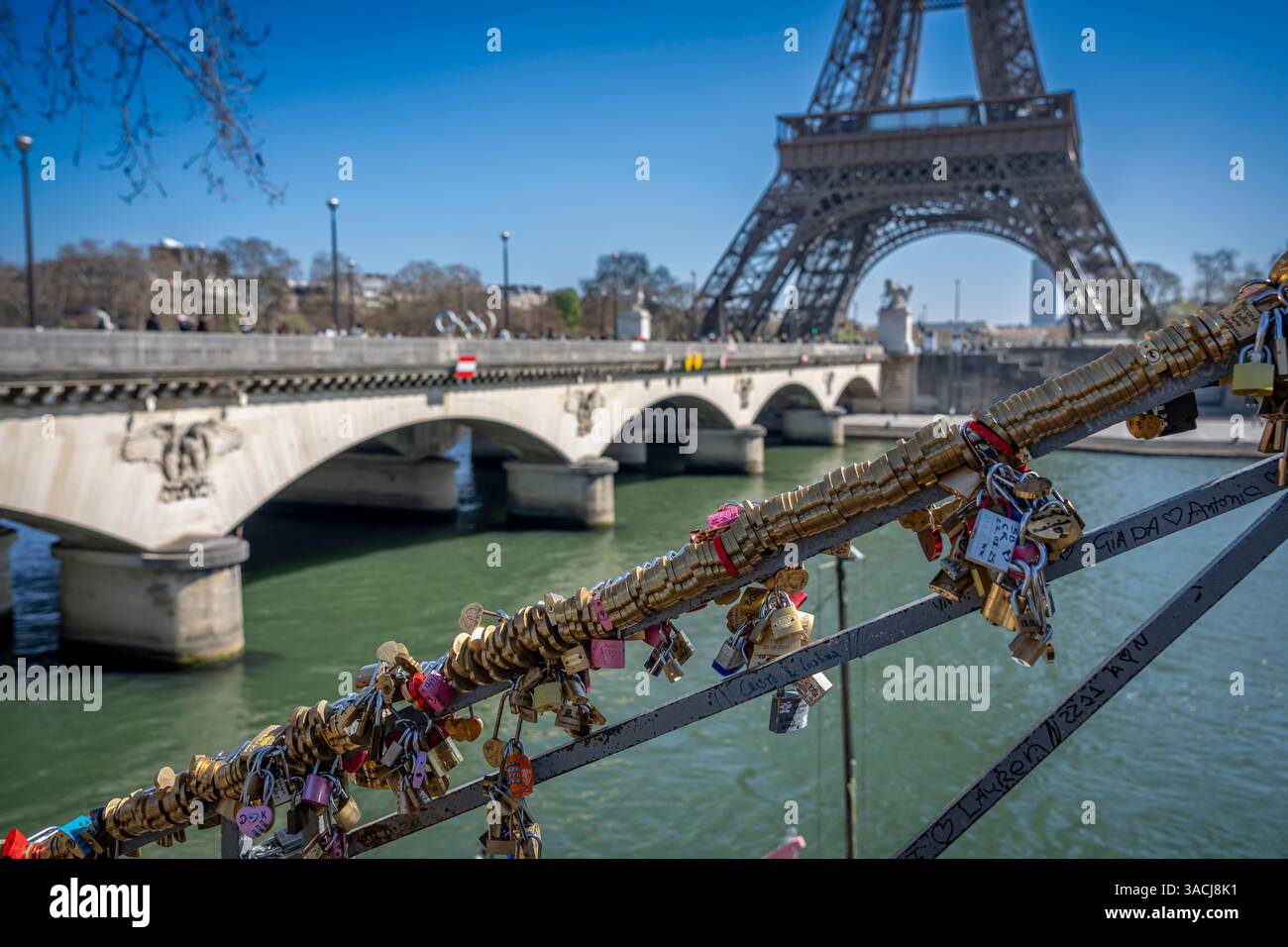 Paris, Frankreich - 03 31 2025: Seine-Quais. Blick auf ein Treppengeländer voller Vorhängeschlösser, Eiffelturm und Iena Bridge dahinter Stockfoto