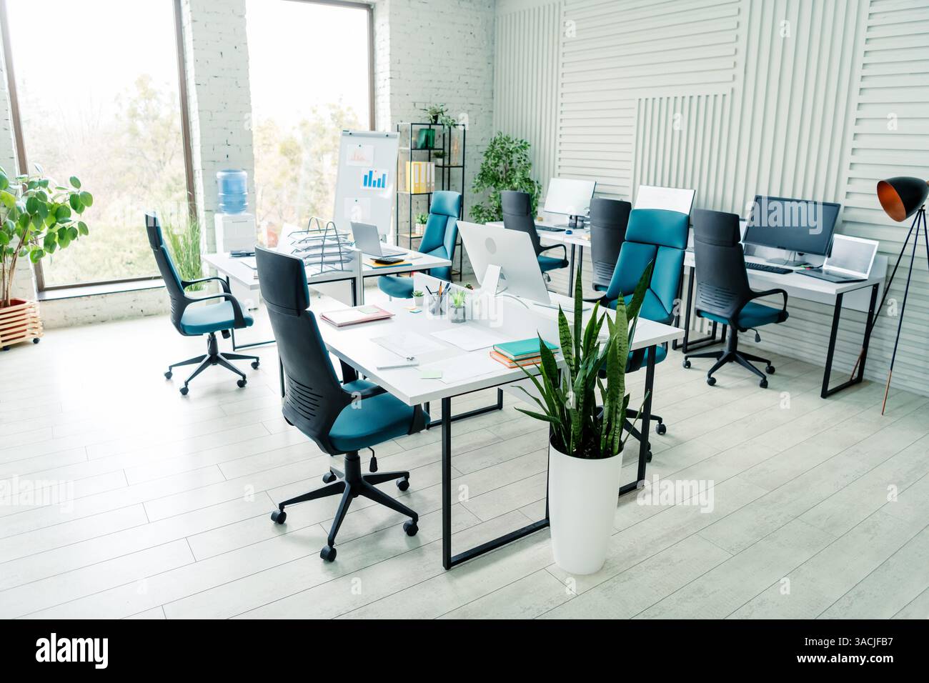 Moderner Coworking-Raum mit stilvollem Büroinnenraum mit Schreibtischen, Stühlen und Tageslicht für gemeinschaftliche Arbeit Stockfoto