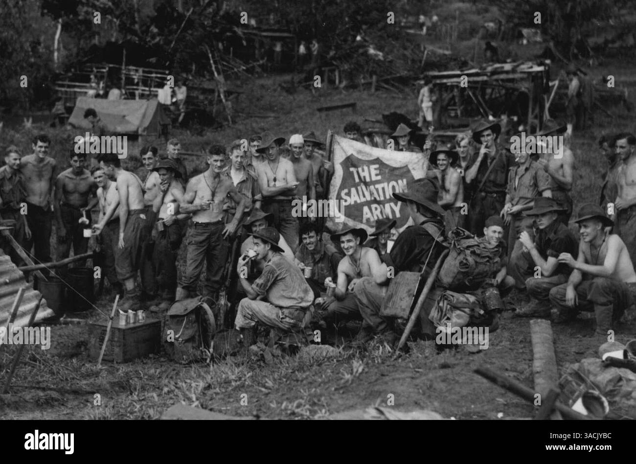 Als die Einheitsflagge in Wareo gehisst wurde, stellte Mr. S. (Tex) Morton, Offizier der Heilsarmee, sein Schild auf. Er folgte der Einheit durch und der A.I.F. kann die Heilsarmee nicht genug loben. Er wird hier hinter seinen Kaffee-„Geschirren“ gezeigt. Januar 1944. Stockfoto