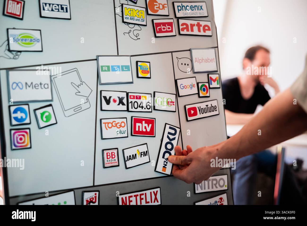 Berlin, Deutschland. April 2025. Logos verschiedener Medien- und Digitalunternehmen – darunter öffentliche Rundfunkanstalten, private Rundfunkanstalten, Social-Media-Plattformen und Streaming-Dienste – auf einer Magnettafel während sie in der America Memorial Library am DesInfoPoint für Medienkompetenz und den Umgang mit Fake News waren. Das Motto der vom Deutschen Bibliotheksverband (dbv) organisierten "Nacht der Bibliotheken" lautet "Wissen". Teilen. Entdecken“. Quelle: Christoph Soeder/dpa/Alamy Live News Stockfoto