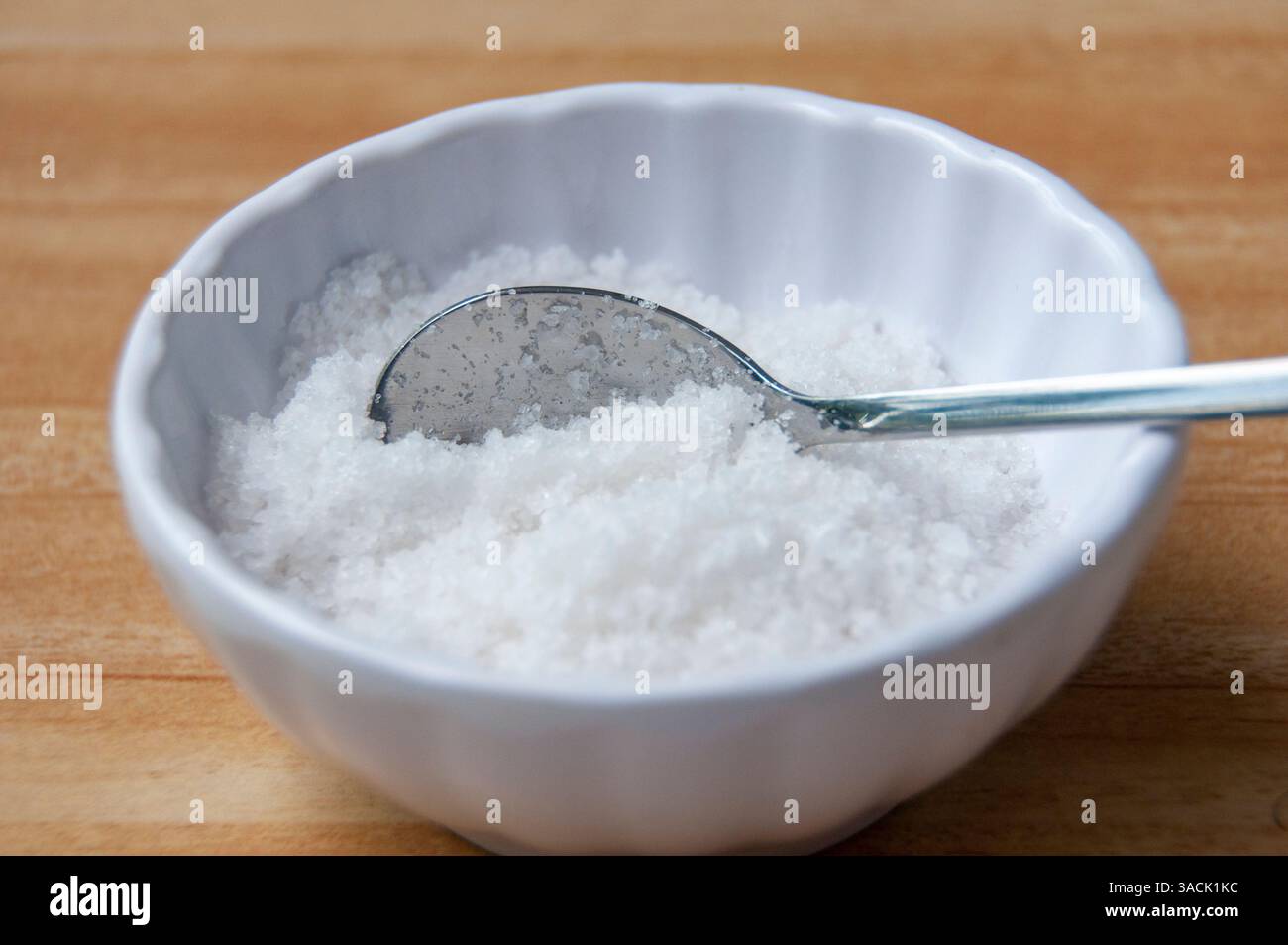 Nahaufnahme eines mit grobem Salz gefüllten Löffels mit anpassbarem Platz für Text oder Ideen. Stockfoto