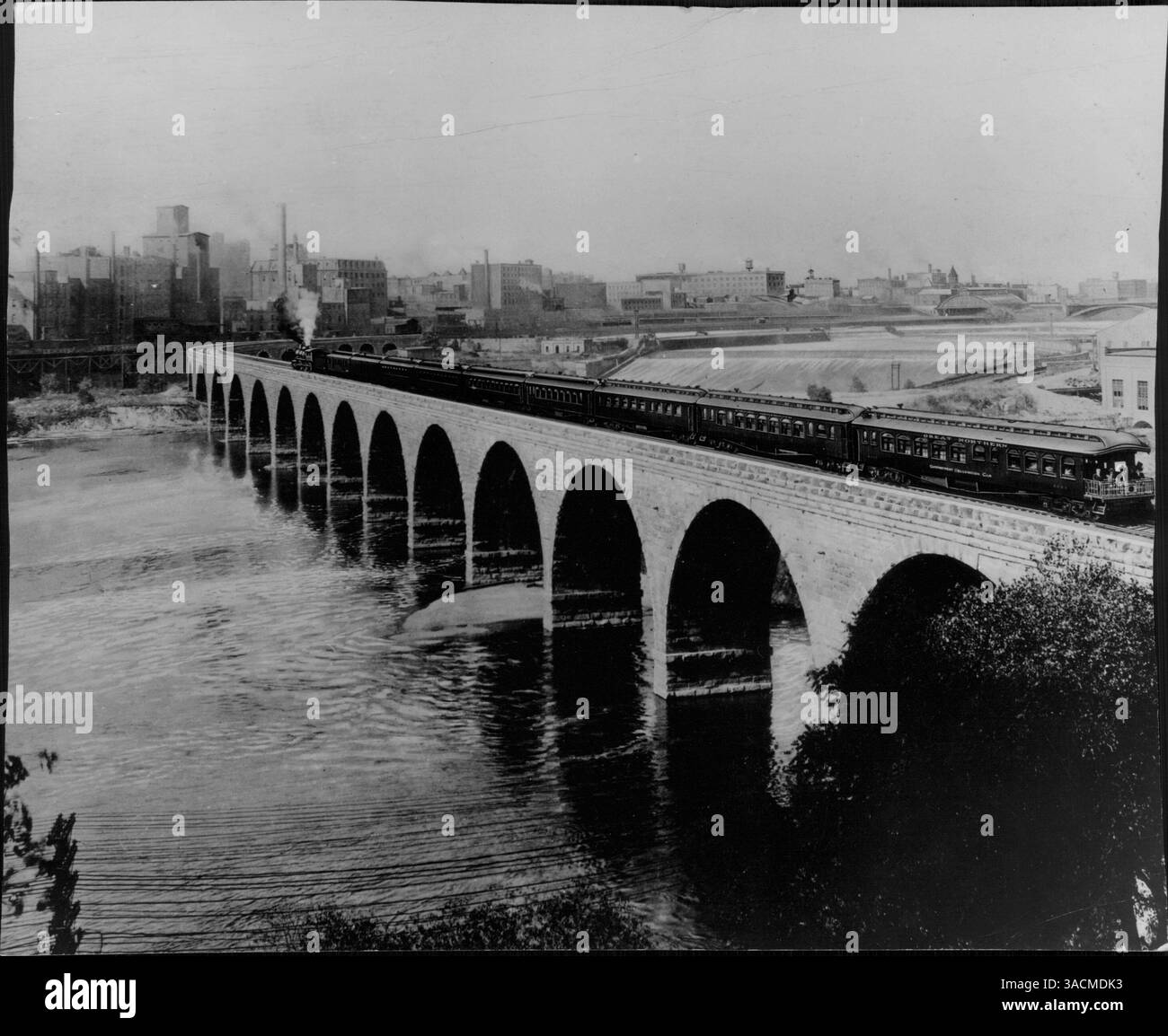Der Empire Builder der Great Northern Railway war ein Luxuszug, der von James J. Hill für die transkontinentale Reise eingeweiht wurde. Der Zug fährt auf seiner ersten Fahrt an der Pazifikküste nach Minneapolis, vorbei am Mehl Milling District und St. Anthony Falls. Stockfoto