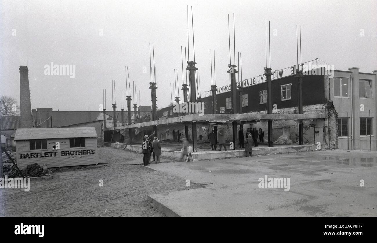 1950er Jahre, historische Bauarbeiten an den Buttercross Works der Whitney Blanket Company Ltd, Whitney, Oxford, England, Großbritannien. Bauunternehmer Bartlett Brothers (Whitney) Limited, wie auf der Bauhütte zu sehen. Whitney Decets wurde 1885 als Decken-Veredelungs- und Reinigungsunternehmen gegründet und entwickelte sich dann in einem Geschäft, das Decken über den Versandhandel verkauft. Die kleine Stadt Witney in Oxfordshire wurde berühmt für ihre Decken, die in die ganze Welt exportiert wurden. Stockfoto