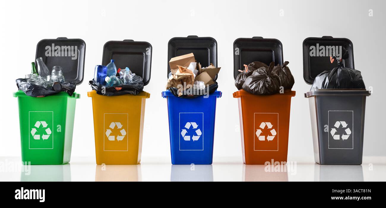 Reihe von offenen mehrfarbigen Recycling-Abfallbehältern aus Kunststoff, gefüllt mit Abfall, mit Recycling-Symbol auf reflektierendem weißem Grund und weiß isoliert Stockfoto